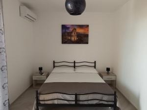 ein Schlafzimmer mit einem Bett und einem Bild an der Wand in der Unterkunft B&B SAINT LOUIS in Presicce