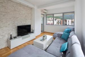 ein Wohnzimmer mit einem Sofa und einem TV in der Unterkunft City center lux apartment in Budva