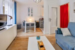 a living room with a blue couch and a table at Studio Faidherbe - Welkeys in Les Lilas