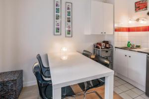 a kitchen with a white table and chairs at Studio Faidherbe - Welkeys in Les Lilas