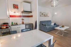 a kitchen and living room with a table and a couch at Studio Faidherbe - Welkeys in Les Lilas