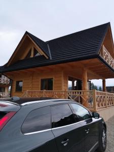 a car parked in front of a log cabin at DOMEK POD LIMBAMI IV in Kluszkowce