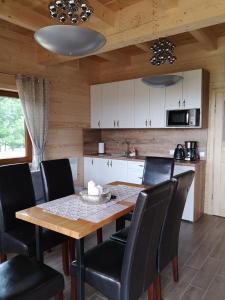 cocina con mesa de madera y sillas negras en DOMEK POD LIMBAMI IV, en Kluszkowce