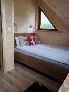 a small room with a bed in a wooden cabin at DOMEK POD LIMBAMI IV in Kluszkowce