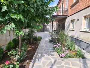 a walkway in front of a house with flowers at Guest House Panda in Kutaisi