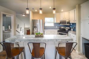 a kitchen with a large island with three bar chairs at Lakeside Family Condo Near Horseshoe Bay Resort in Horseshoe Bay