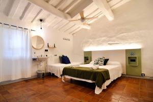 1 dormitorio con 2 camas y ventilador de techo en Hostal l'Estrella, en Palafrugell