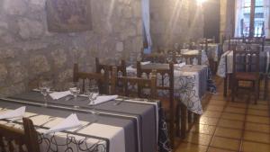 un comedor con mesas y sillas y copas de vino en Fonda la Plaza en Valderrobres