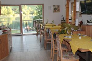 ein Restaurant mit Tischen und Stühlen und einem Balkon in der Unterkunft Frühstückspension Seerose in Weissensee