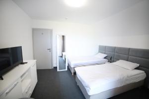 ein Hotelzimmer mit 2 Betten und einem Flachbild-TV in der Unterkunft WILLA ILONA 1 in Łeba