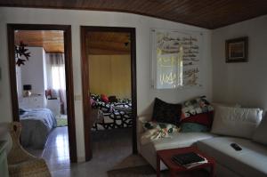 a living room with a couch and a bedroom at Ollar do Cido in Seoane