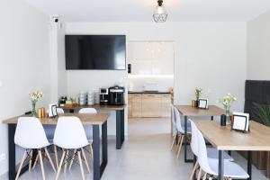 a dining room with wooden tables and white chairs at WILLA ILONA 1 in Łeba