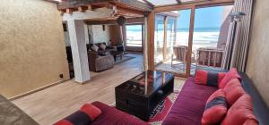 a living room with a couch and a view of the ocean at Frikrik maison au bord de mer in Zaouit Aglou