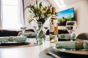 a table with a bottle of wine and glasses at Seaforth House Apartment in Elgin