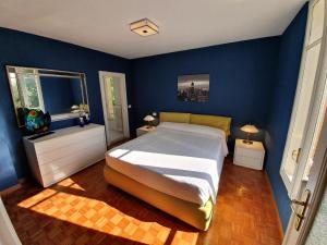 a bedroom with a large bed and blue walls at Villa Serendipità in Gardone Riviera