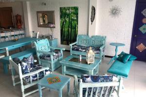 卡利馬的住宿－CHALET SANTORINI，一间设有蓝色椅子、桌子和桌子的房间