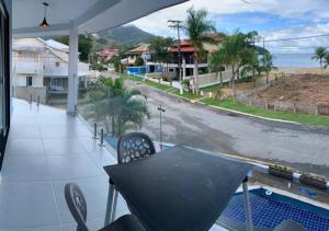 balkon ze stołem i widokiem na ulicę w obiekcie Flats Catamarã w mieście Angra dos Reis