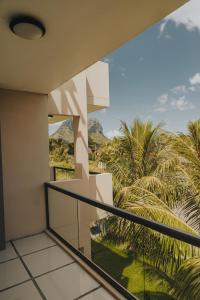 een balkon met uitzicht op palmbomen en bergen bij Luxe Exotica Apartments in La Gaulette