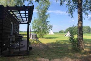 een uitzicht op een veld met tenten op de achtergrond bij Birch house in (( Šarlote ))
