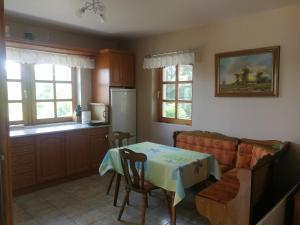 a living room with a table and a couch and a kitchen at Bottyahát guesthouse in Rezi