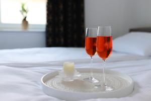 two glasses of wine on a plate on a bed at WILLA ILONA 1 in Łeba