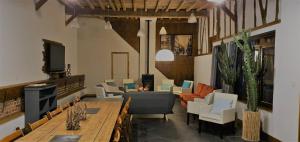 a living room with a couch and a table and chairs at Le Domaine d'Hérambault in Montcavrel