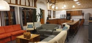 a living room with couches and tables and a kitchen at Le Domaine d'Hérambault in Montcavrel