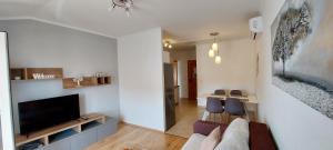 a living room with a couch and a flat screen tv at Apartments Marijana in Rab