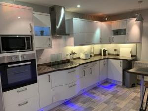 a kitchen with white cabinets and white appliances at Westend Holiday Room 4 Brecon in Brecon