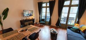 uma sala de estar com uma mesa e um sofá azul em Les balcons de Dieppe - appartement 1ER étage - certifié 3 étoiles au cœur de la rue piétonne em Dieppe