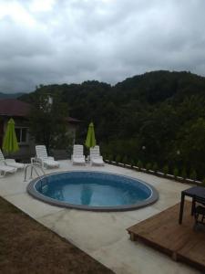 a swimming pool with chairs and a table at вила Ирена in Radevtsi