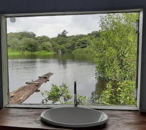 uma janela de casa de banho com um lavatório e vista para um rio em Amazônia Exxperience em Manaus