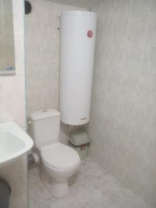La salle de bains est pourvue de toilettes blanches et d'un lavabo. dans l'établissement Квартири - стаи за гости, Ахтопол, à Ahtopol