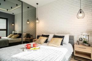 - une chambre avec un grand lit blanc et des miroirs dans l'établissement ArtApart Market Square Wrocław, à Wrocław