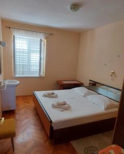 a bedroom with a bed with two towels on it at Kuća Lidija in Rab