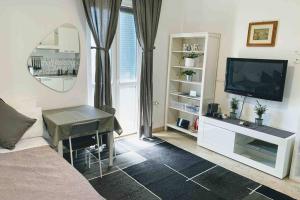 uma sala de estar com uma televisão e um sofá em Short rent milan em Milão