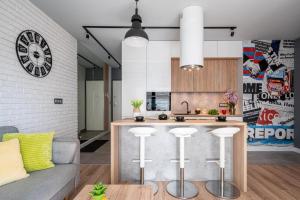 a kitchen with a bar with stools and a counter top at Art Apart Old Town Wrocław in Wrocław