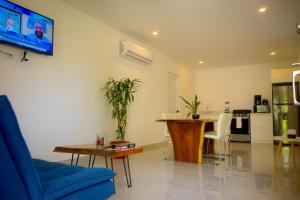 sala de estar con sofá azul y mesa en Casa Coco de Mer 1, en Tamarindo