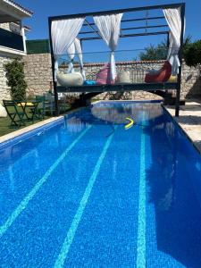 a large blue swimming pool with a table and chairs in it at Grand Alaçatı Butik Hotel in Alaçatı