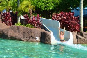 a little girl on a slide in the water at a resort at Pili Aloha in Koloa
