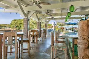 a restaurant with tables and chairs and umbrellas at Pili Aloha in Koloa