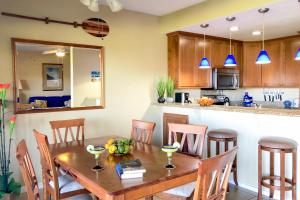 a kitchen and dining room with a wooden table and chairs at Poipu Sands 214 in Kipu