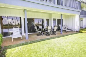 a patio with chairs and tables on a house at Poipu Sands 214 in Kipu