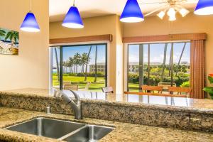 a kitchen with a sink and a view of a patio at Poipu Sands 214 in Kipu