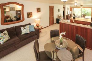 uma sala de estar com um sofá e uma mesa em Waikomo Streams 202 em Kipu