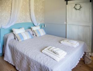 un letto blu con sopra asciugamani di La casetta sulle Stelle a Stella