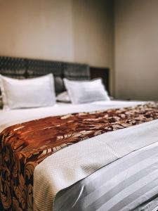1 dormitorio con 2 camas y almohadas blancas en Hotel Kompleksi Arifi, en Shkodër