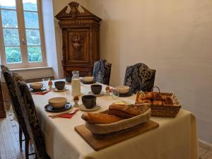 a table with a white table cloth and bread on it at La Caminada Vielha in Montaillou +38 photos