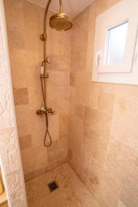 una doccia con soffione in un bagno di Casa Cardiccia a Folelli