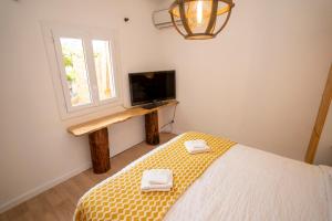 una camera da letto con un letto, una tv e una finestra di Casa Cardiccia a Folelli